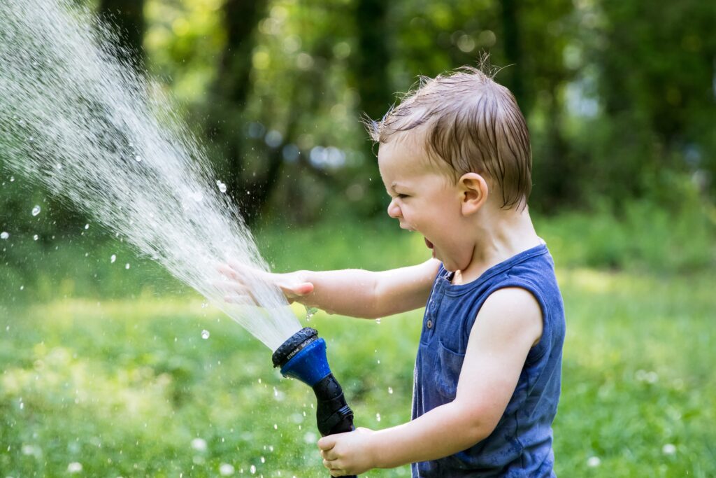屋外で水遊びをする子ども